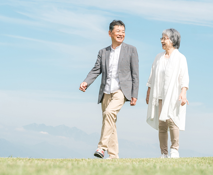 湘南の海辺を散歩するシニア世代